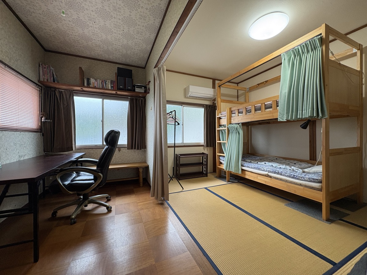 長期滞在者向けのシェアハウスの部屋。デスクと2段ベッドのある和室